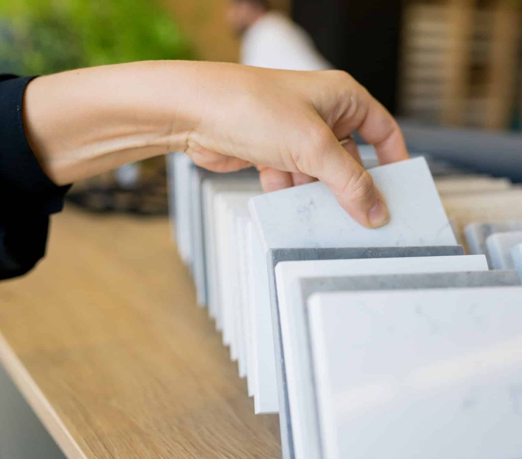 close up of woman choosing quartz materials for countertops in the kitchen